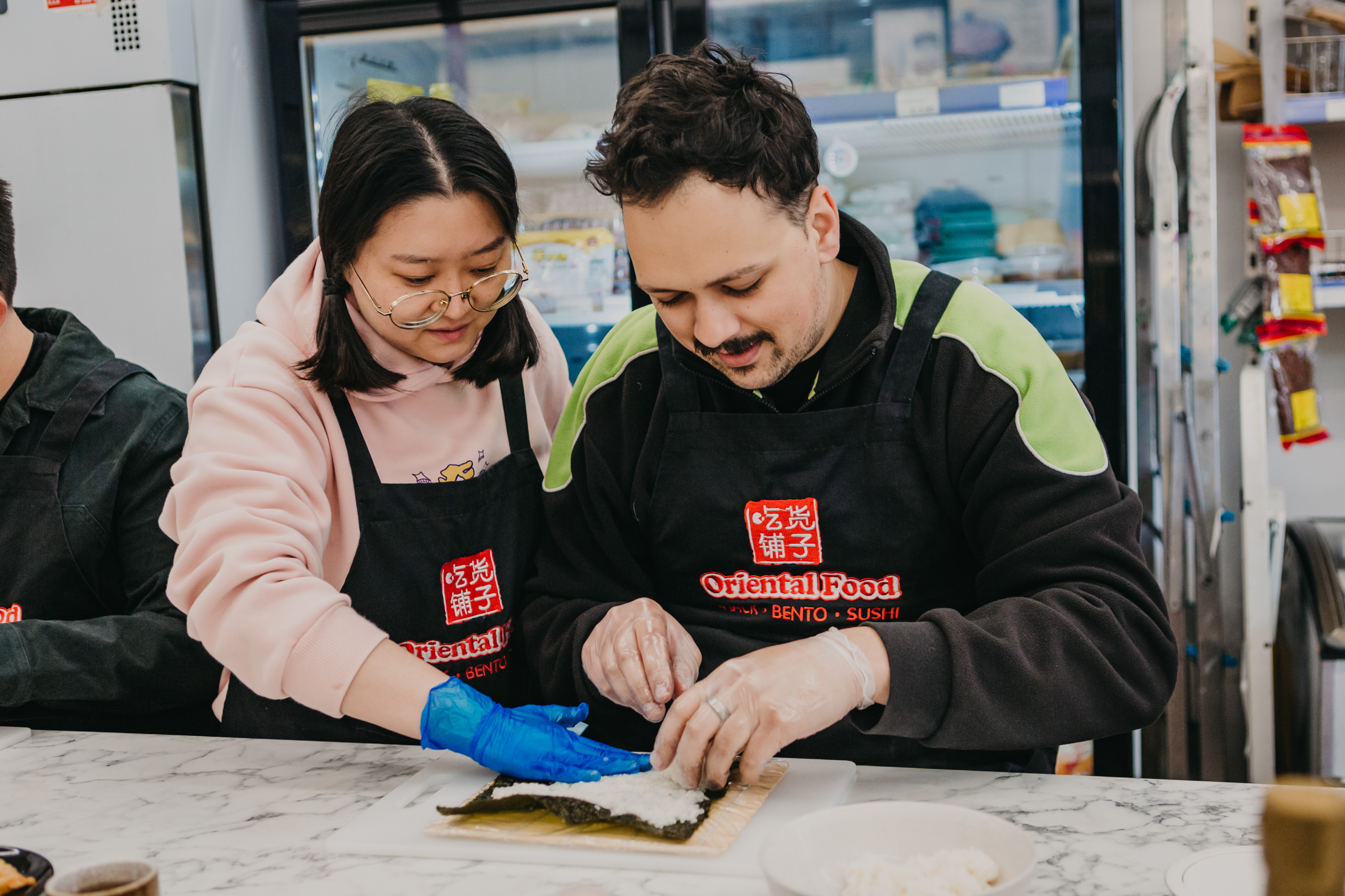 Man and woman rolling sushi in a sushi making class